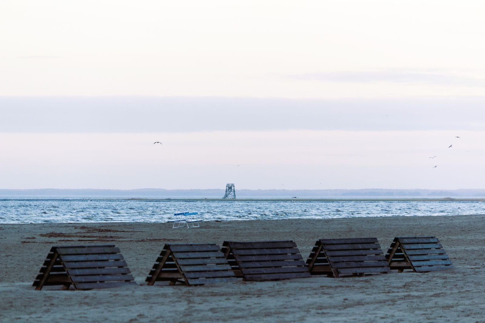 Leerer Nordseestrand im Winterlicht mit gestapelten Strandbänken